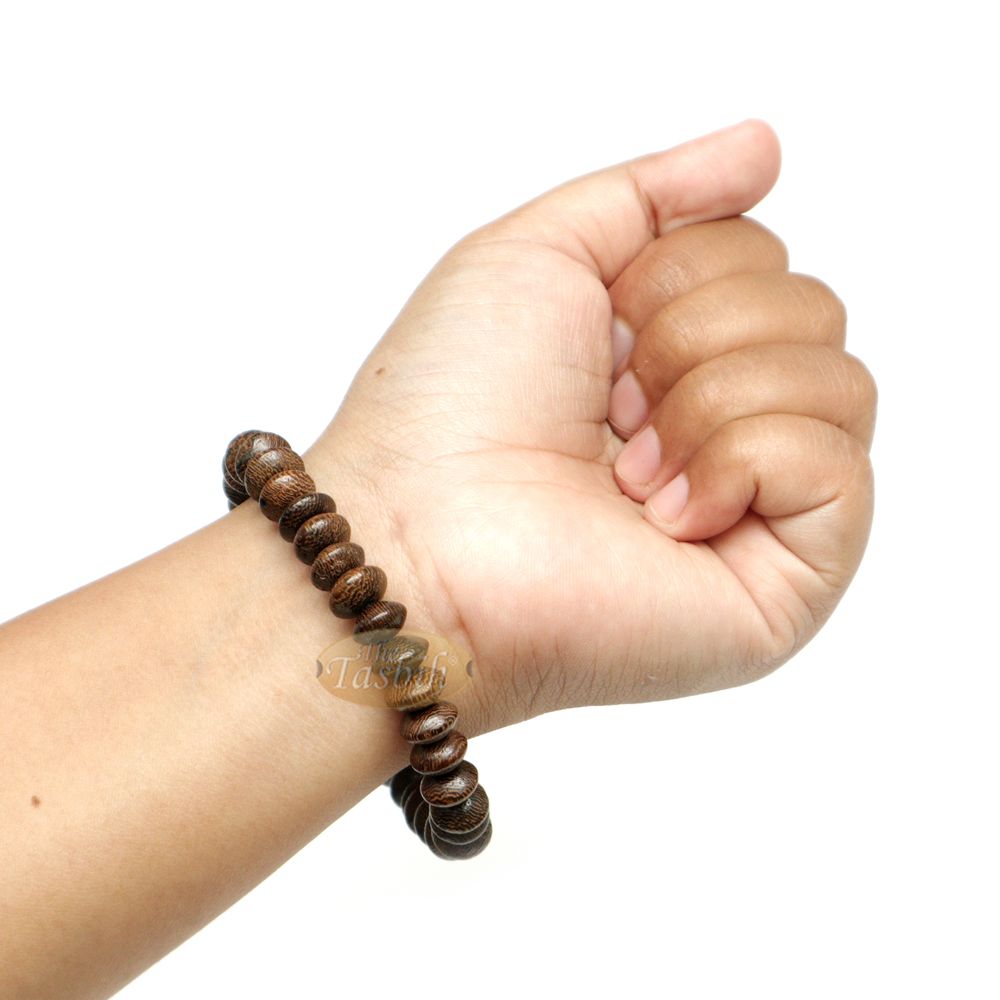 Natural brown wooden tasbih bracelet with oval beads arranged on an elastic band.