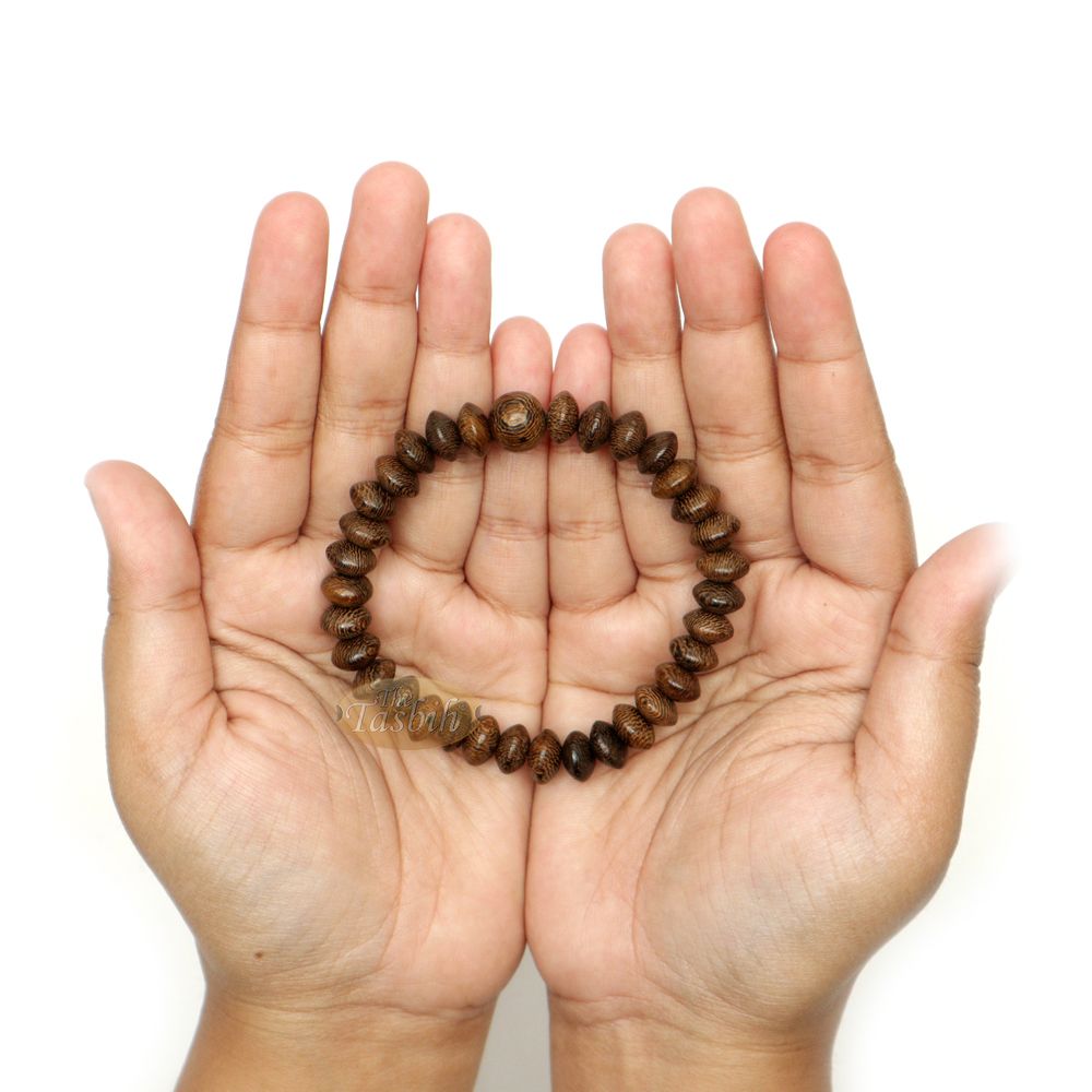 Natural brown wooden tasbih bracelet with oval beads arranged on an elastic band.