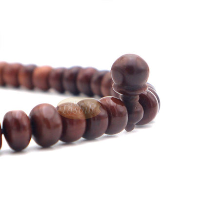 Brown wooden Islamic misbaha with rounded prayer beads and a black tassel cord.