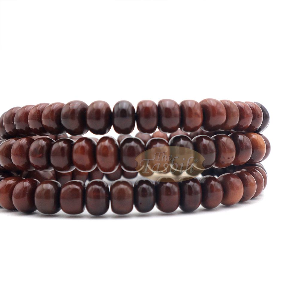 Brown wooden Islamic misbaha with rounded prayer beads and a black tassel cord.