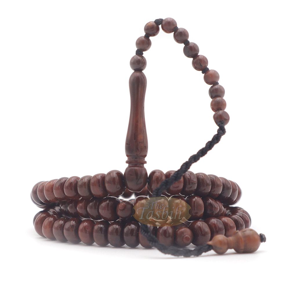 Brown wooden Islamic misbaha with rounded prayer beads and a black tassel cord.