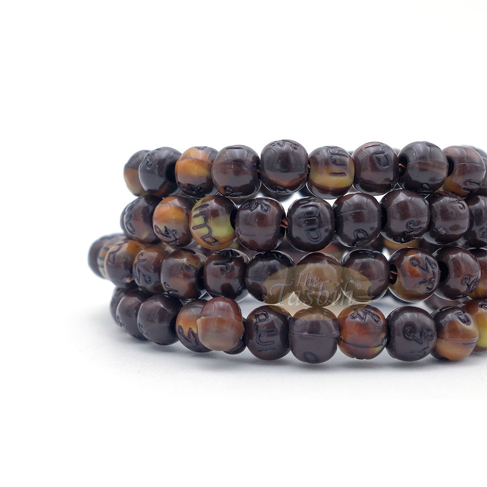 Brown and black patterned wooden Islamic misbaha prayer beads with braided tassel cord.